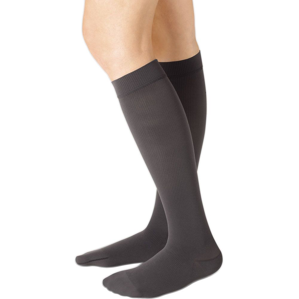 Dunkelgraue Kompressionsstrümpfe, Kniestrümpfe, geripptes Material, Noppenhaftrand. Seitliche Ansicht, auf Beinen getragen.