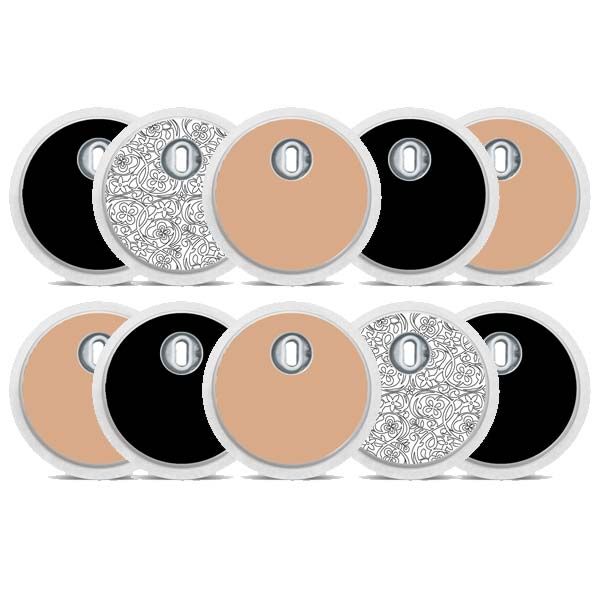 Mehrere runde Aufkleber. Einige schwarz, einige beige, einige mit floralem Muster. Alle haben eine Öffnung in der Mitte.