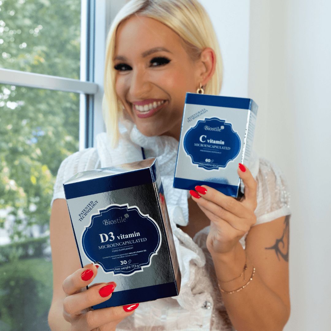 Frau hält zwei Biostile-Boxen: D3 Vitamin und C Vitamin. Beide Boxen sind blau und silberfarben.