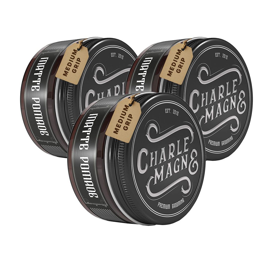 Drei schwarze Dosen mit Etiketten, die 'Matte Pomade' und 'Charles Magn&' zeigen.