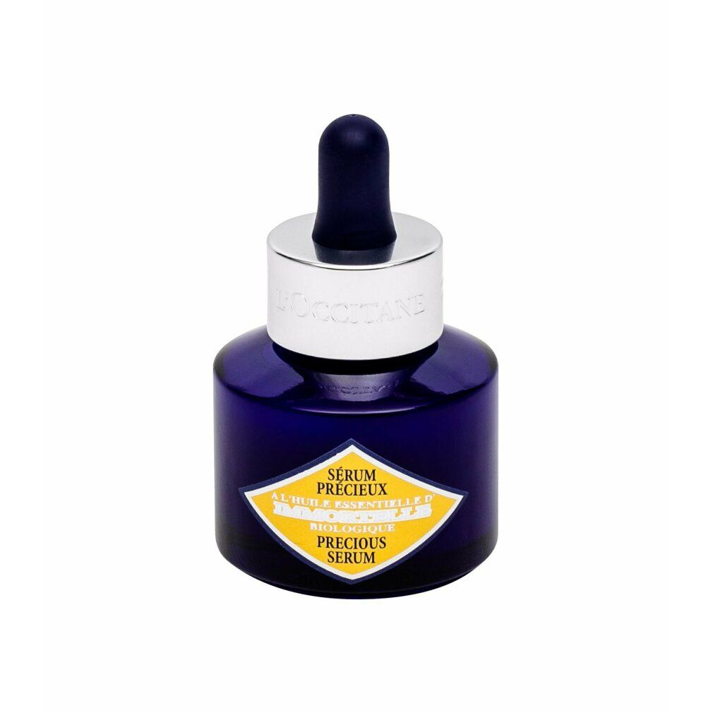 Dunkelblaue Flasche mit silbernem Verschluss und Pipette. Gelbes Etikett mit Text. Produktname: Sérum Précieux.