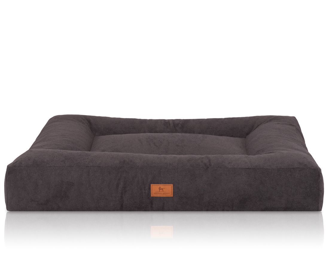 Orthopädisches Hundebett Sofia, rechteckig, dunkelgrau. Erhöhter Rand, flache Liegefläche. Braunes Label mit Logo.