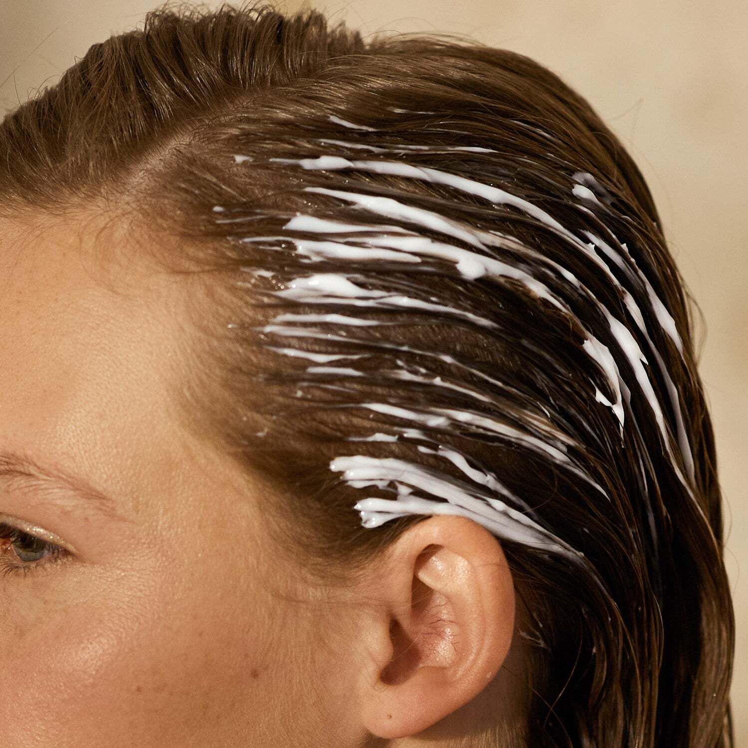Haar mit weißer Creme bedeckt. Creme auf dem Haar verteilt.