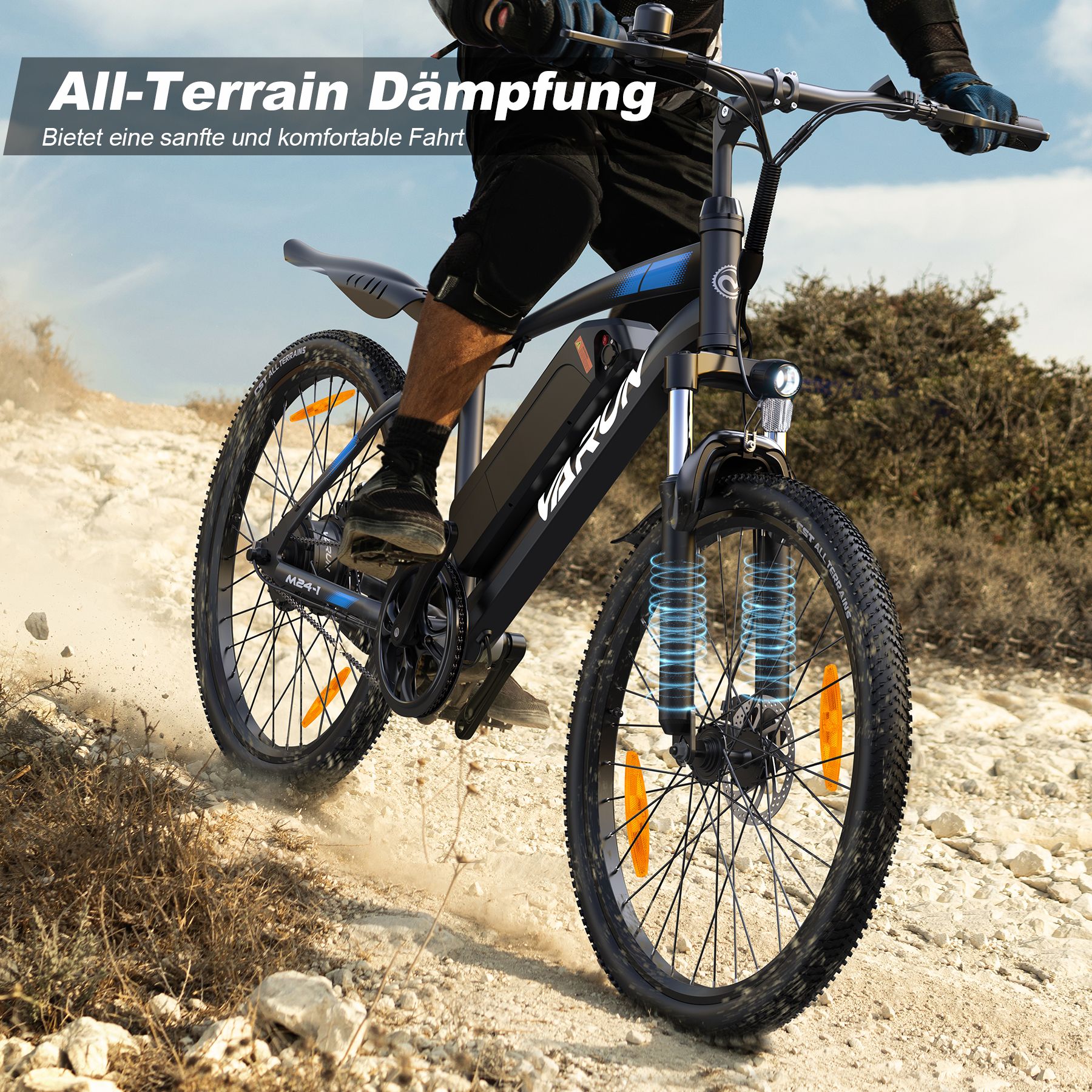 E-Bike in Bewegung auf unebenem Gelände. Sichtbar: VARUN, Federung, orange Reflektoren, schwarze Reifen.