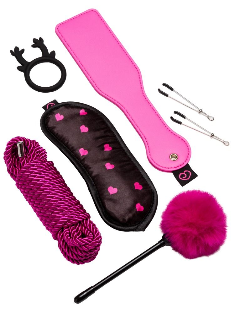 Ein Set mit sieben Artikeln: pinkes Paddel, Augenmaske, Seil, Feder-Peitsche, Ring, Zitzenklemmen.