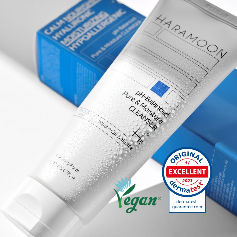 Tube mit Text und veganem Logo. Text: pH-Balanced Pure & Moisture CLEANSER. Wasser-Öl Balance. Dermatest-Siegel.