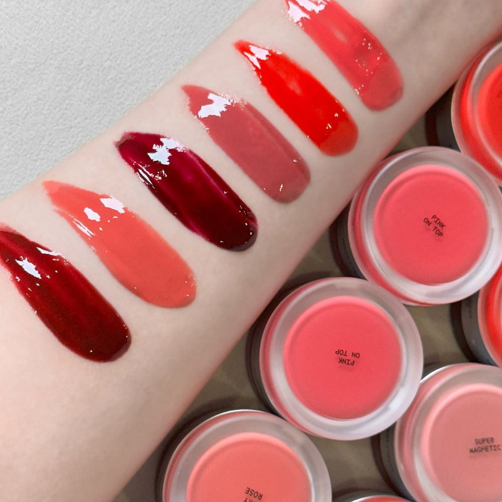 Verschiedene Farbtöne des titto Lip & Cheek Dual Pot auf einem Arm. Farbverläufe von Rot bis Rosa.