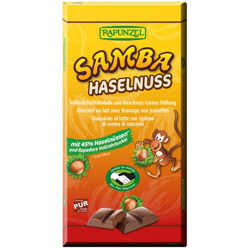 Verpackung von Rapunzel Samba Haselnuss Schokolade. Gelb-orangefarbene Schachtel mit Produktnamen, Illustrationen und Texten.