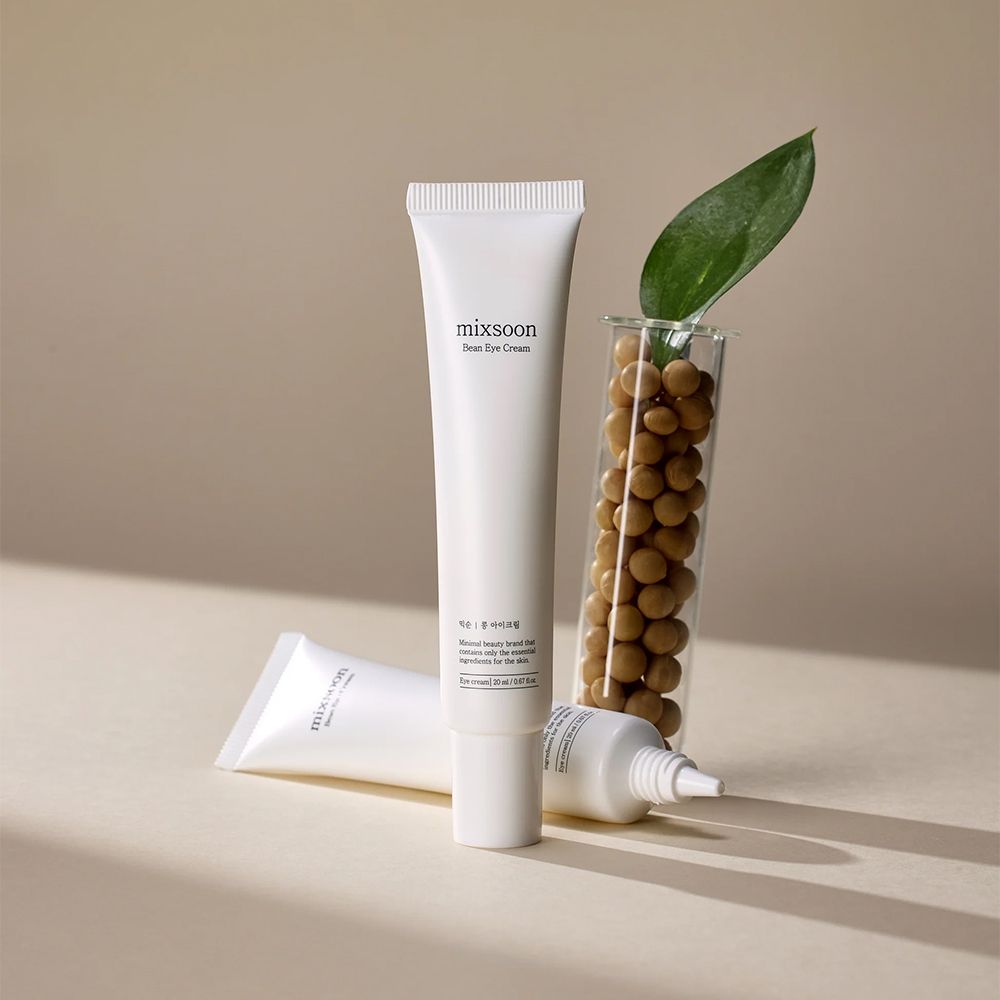 Zwei weiße Tuben Mixsoon Bean Eye Cream, eine davon mit Sojabohnen und Blatt.