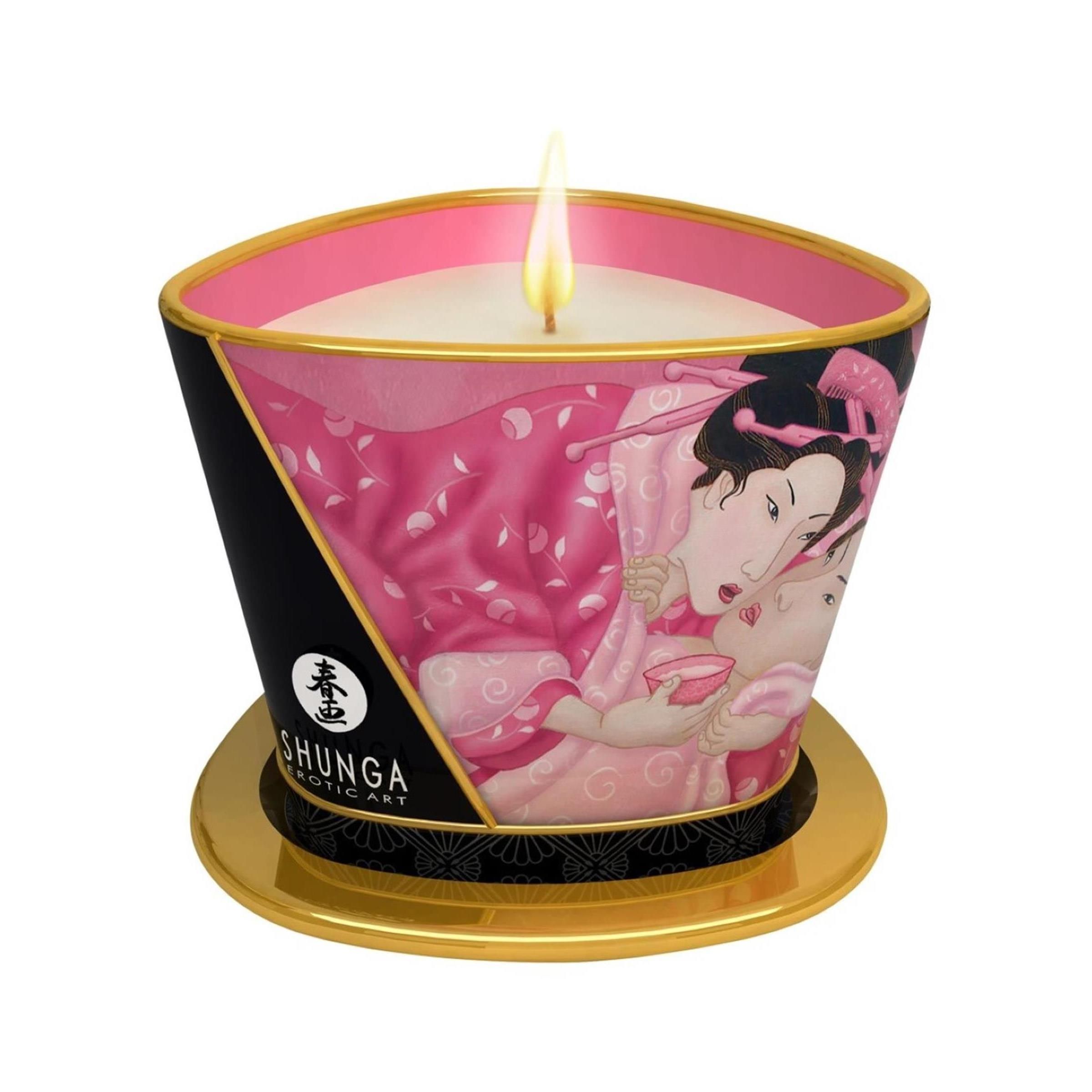Kerze in einem Behälter mit rosa und schwarzem Design. Goldfarbener Rand. Flamme. Aufschrift: Shunga.