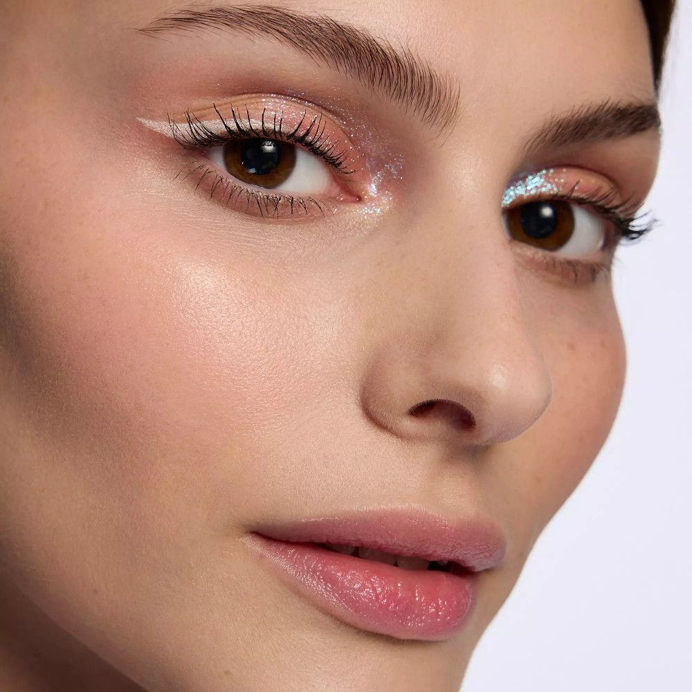 Porträt einer Frau mit weißem Eyeliner. Sichtbare Augen, Lippen und Haut.