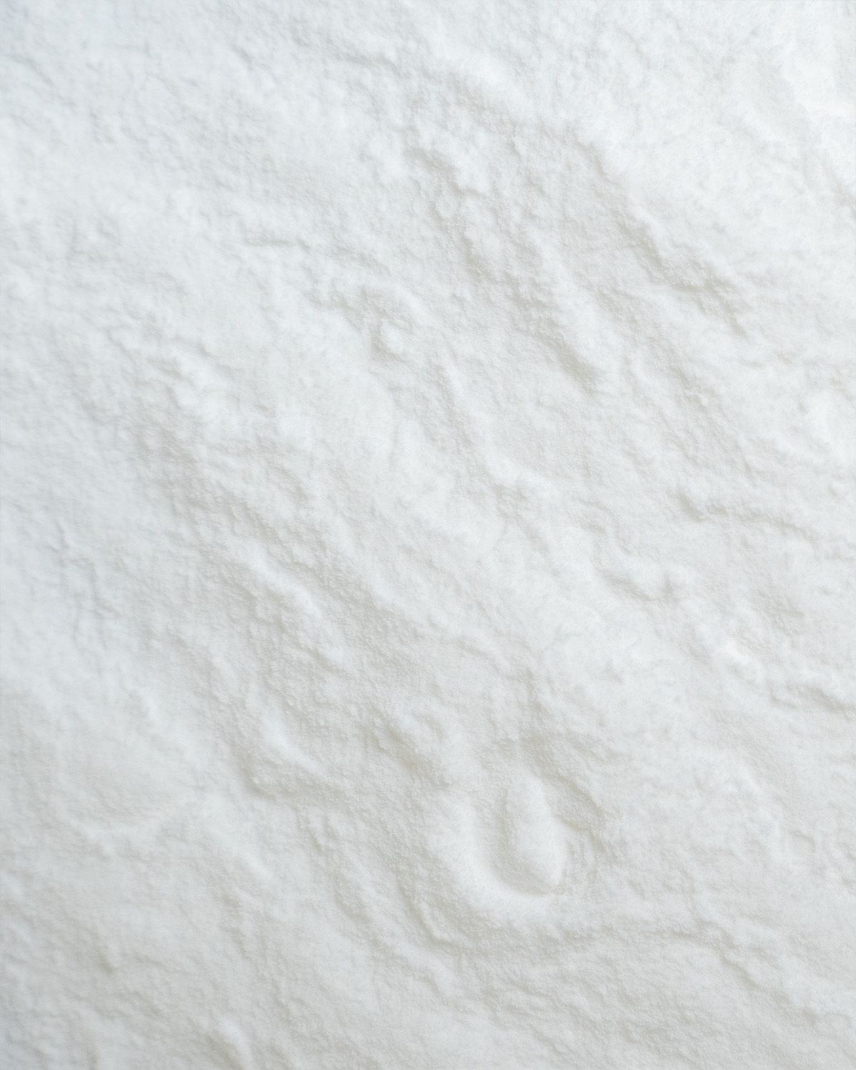Nahaufnahme von weißem Pulver mit wellenförmiger Textur.
