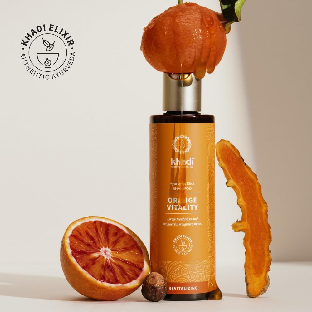 Khadi Orange Vitality Shampoo-Flasche mit Orange und Ingwer. Logo und Produktname auf dem Etikett. Text: Ayurvedisches Elixier, Shampoo, Orange Vitality.
