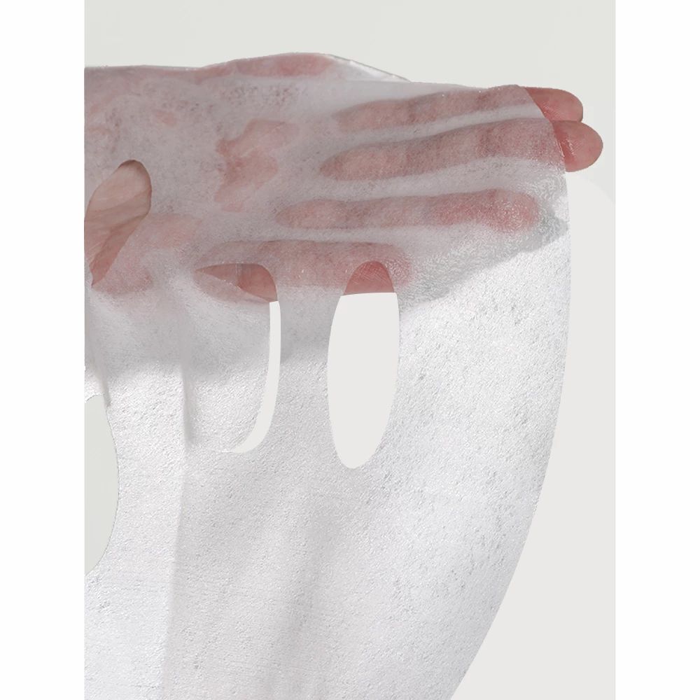 MIZON Joyful Time Essence Mask Acai Berry: Eine Hand hält die durchfeuchtete Gesichtsmaske.