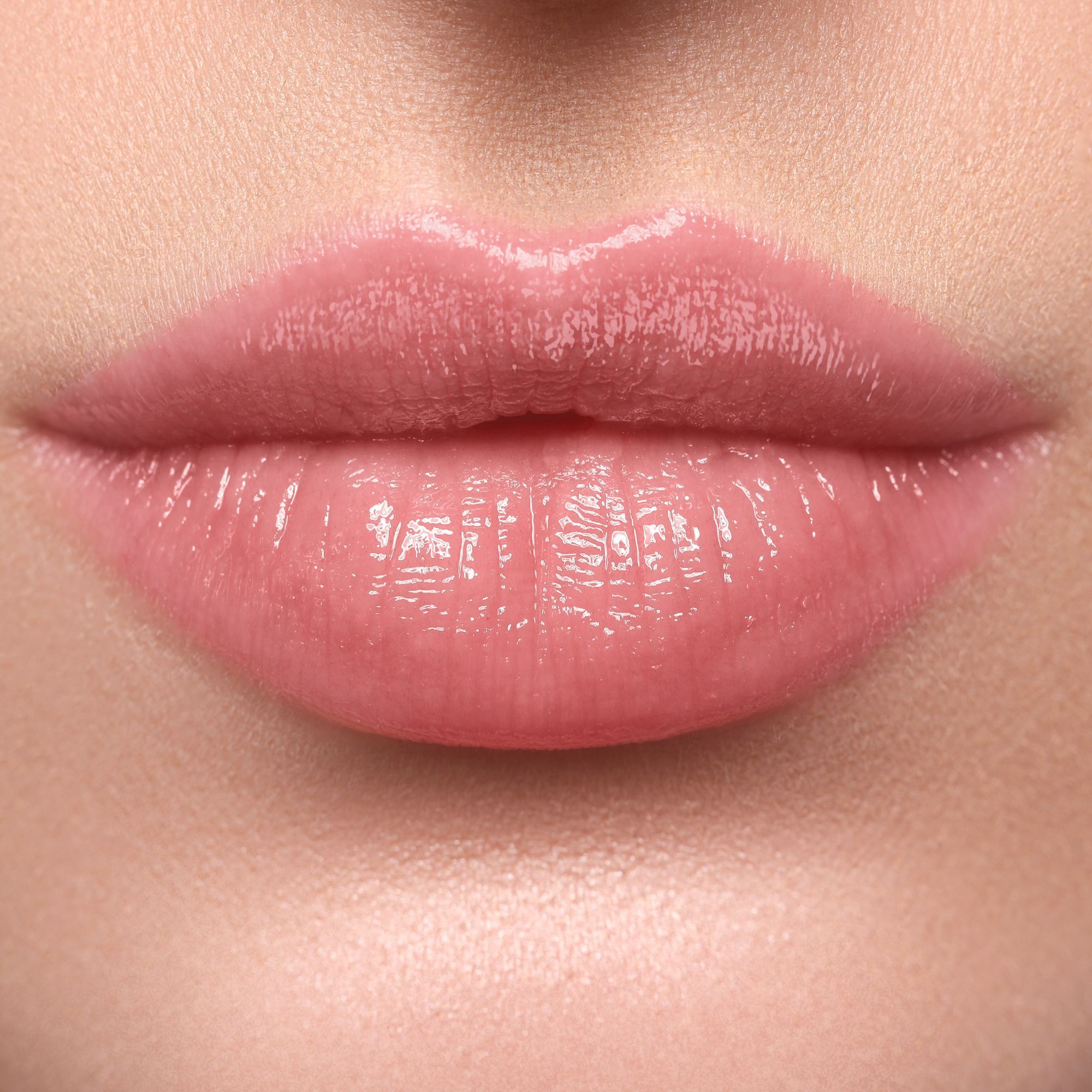 Nahaufnahme von Lippen mit glänzendem, rosa Lippenstift.
