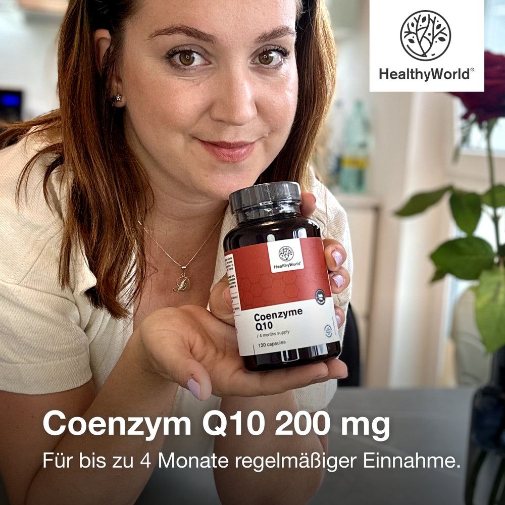 Frau hält Flasche mit HealthyWorld Coenzym Q10. Aufschrift: 200 mg. Für bis zu 4 Monate regelmäßiger Einnahme.
