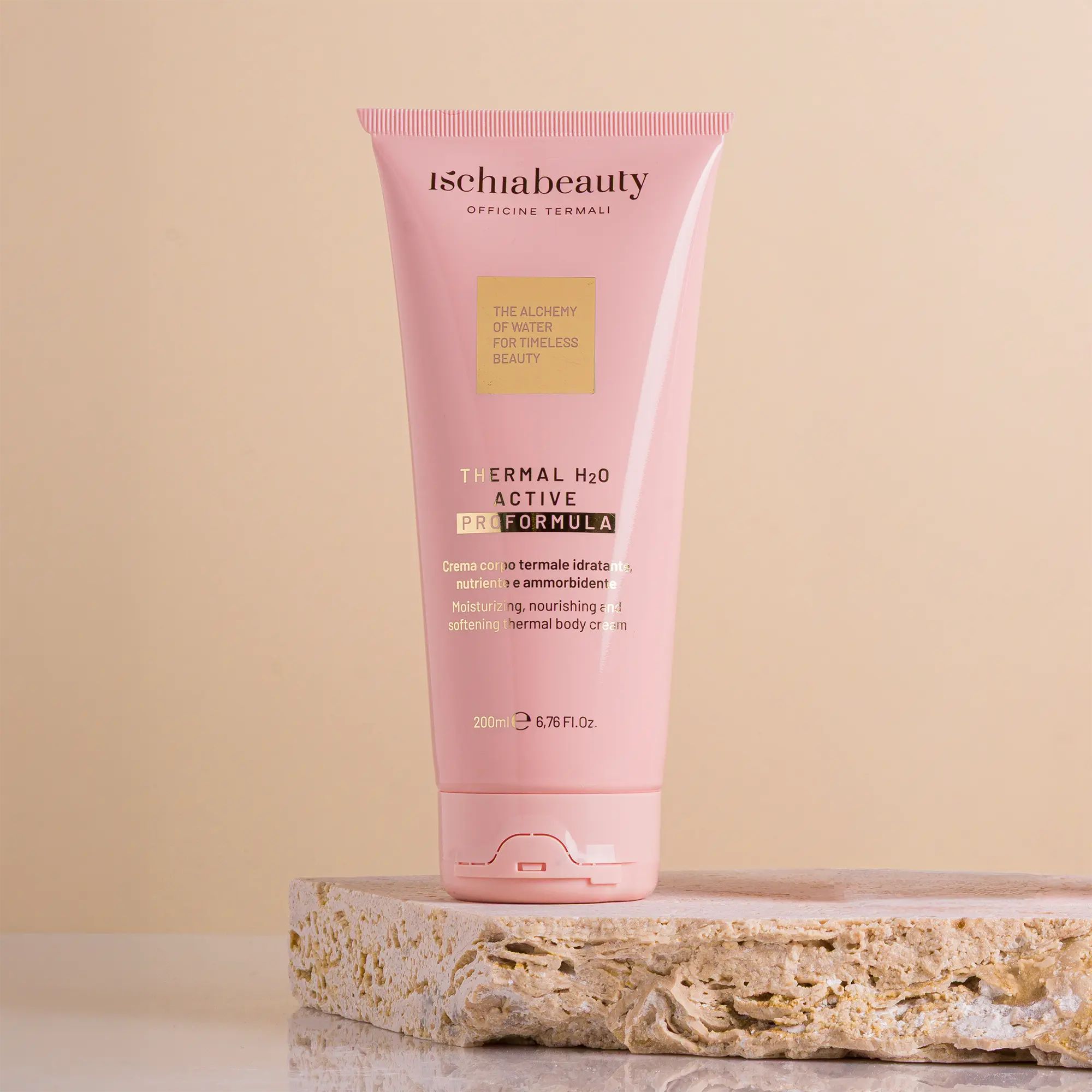 Rosa Tube mit Produkttext. Aufschrift: ischiabeauty, Thermal H2O Active Pro Formula. Auf Stein platziert.