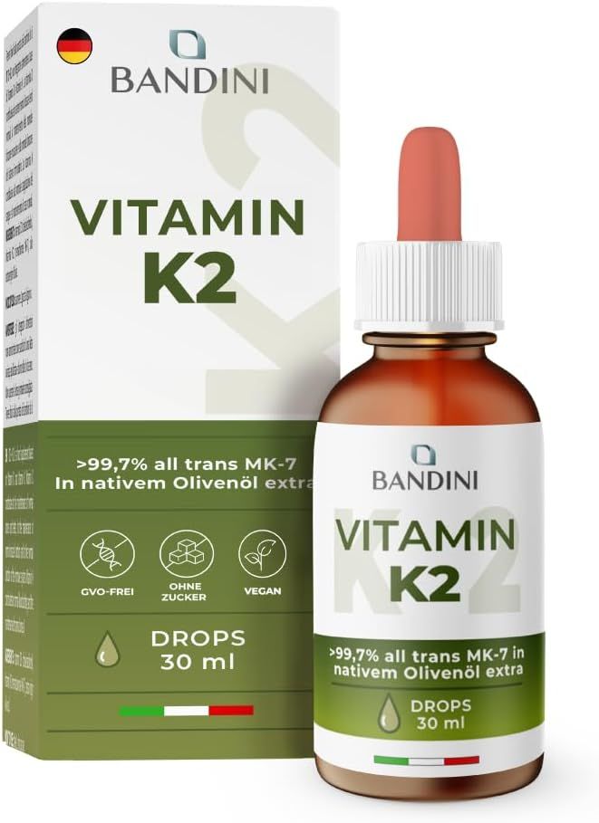 Vitamin K2 Tropfen in Flasche und Verpackung. Aufschrift: Vitamin K2. Text: >99,7% all trans MK-7 in nativem Olivenöl extra. 30 ml.