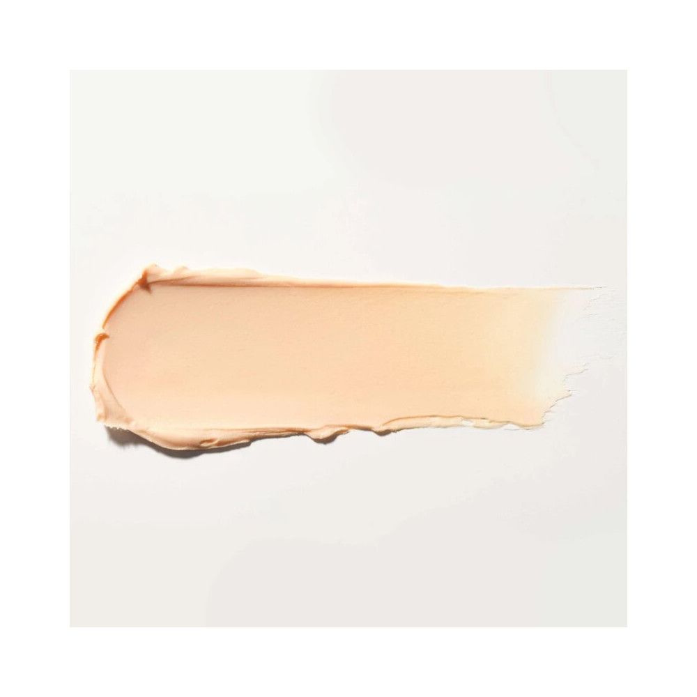 Ein cremefarbener Lippenbalsam-Abstrich auf weißem Hintergrund. Die Textur ist glatt und cremig.