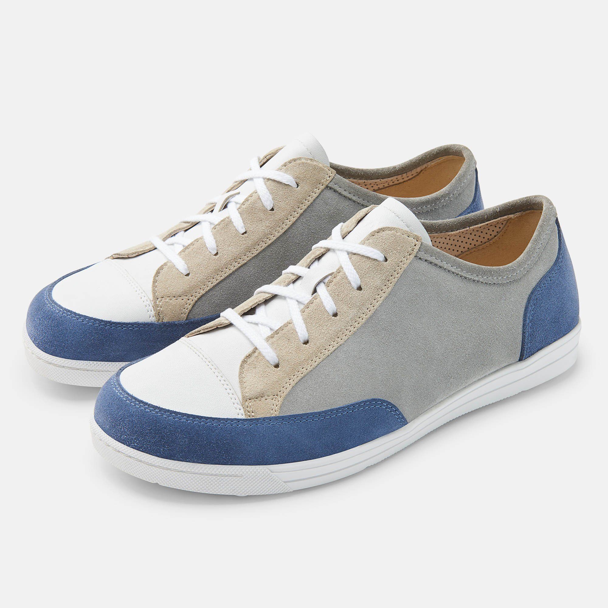Zwei graue, blaue und weiße Schnürschuhe. Die Schuhe haben eine weiße Sohle und Schnürsenkel.