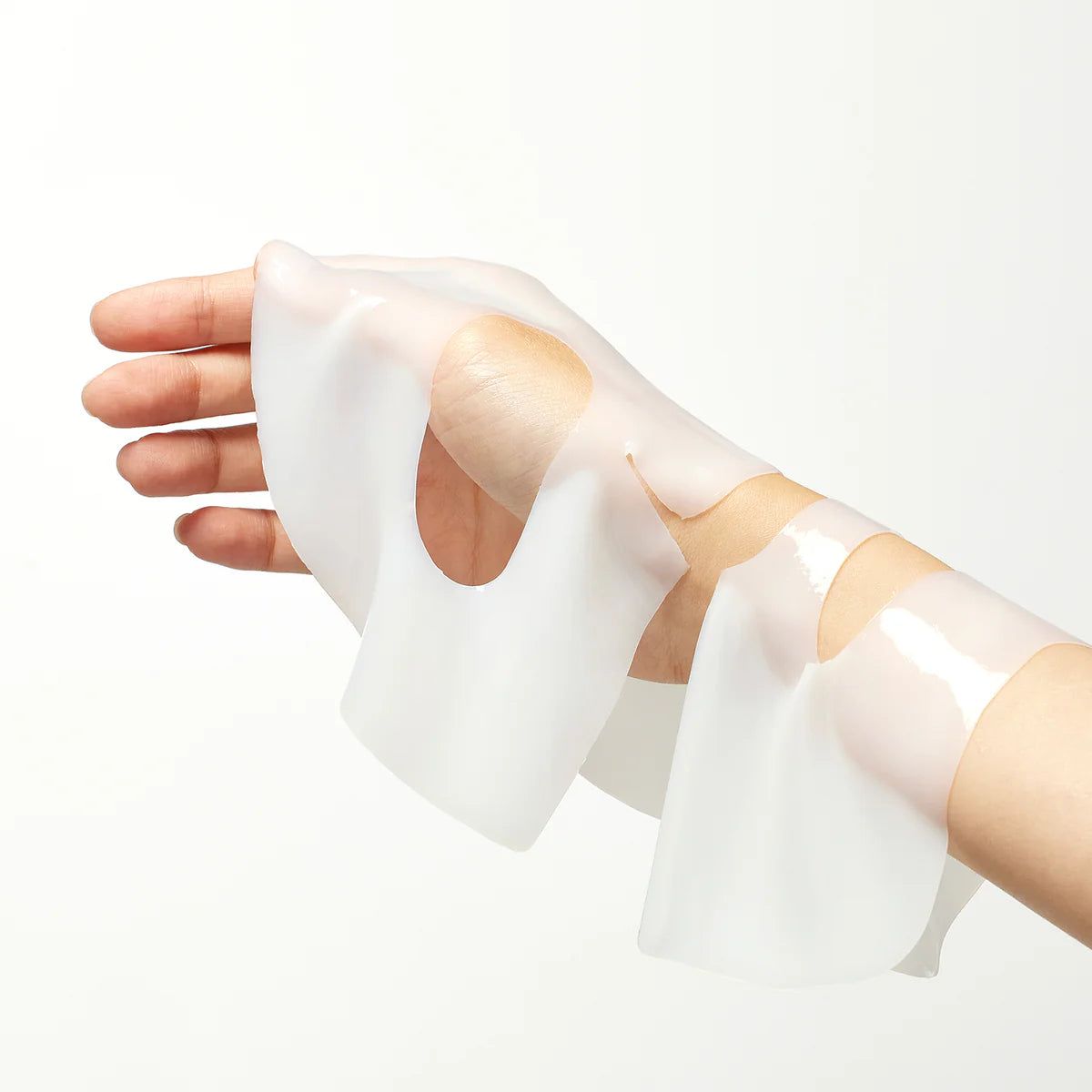 Hand hält eine aufgetragene Hydrogel-Gesichtsmaske.