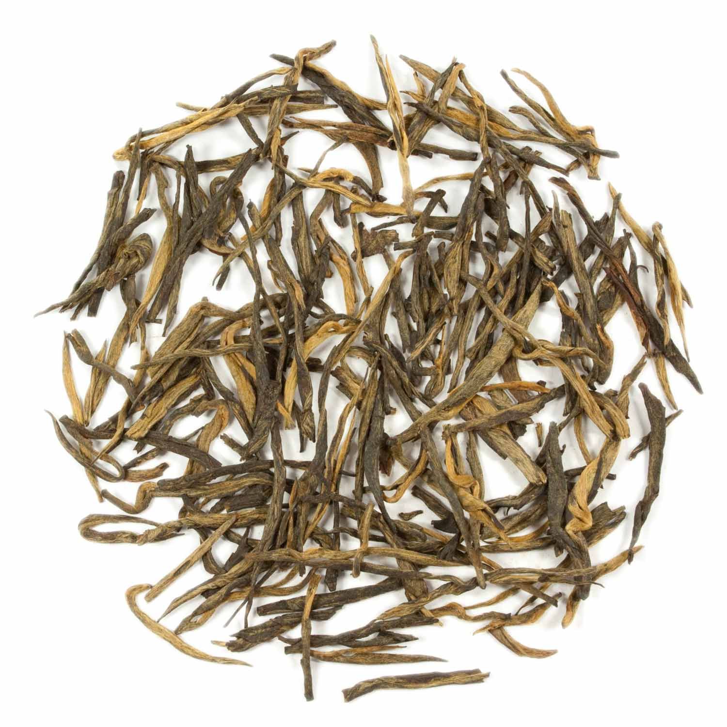 Haufen getrockneter Teeblätter. Verschiedene Brauntöne. Nahaufnahme von losem Tee auf weißem Hintergrund.