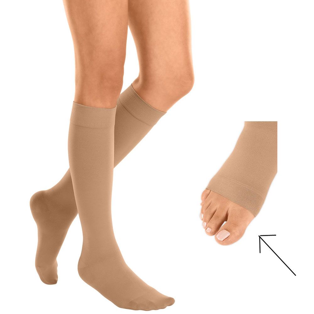 Hautfarbene Kompressionsstrümpfe, knielang, mit offener Fußspitze. Detailansicht des Fußes mit Pfeil. Trikotabschlussrand.