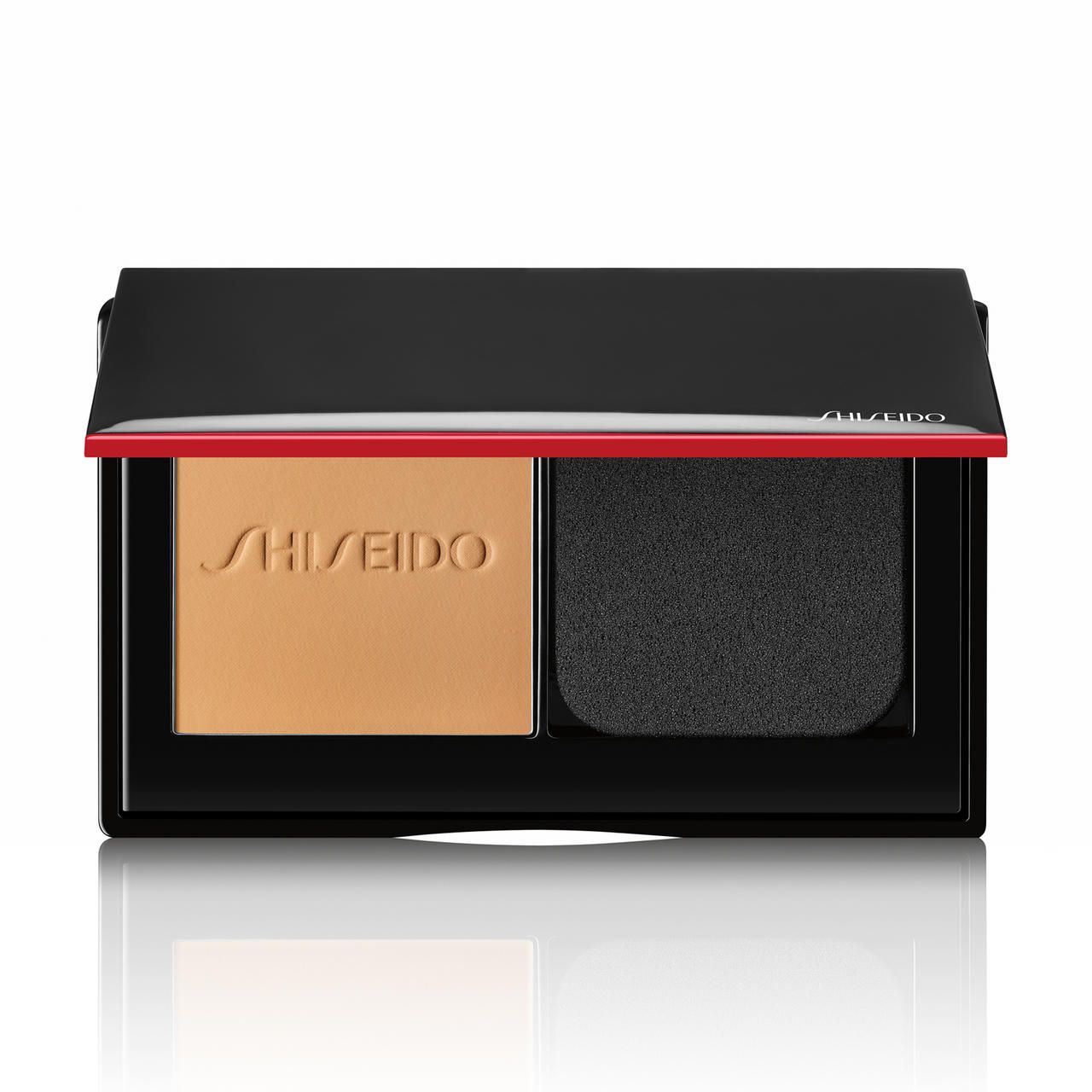 Kompaktpuder-Foundation mit Schwamm und Spiegel. Schwarzes Gehäuse mit rotem Akzent. SHISEIDO-Logo.