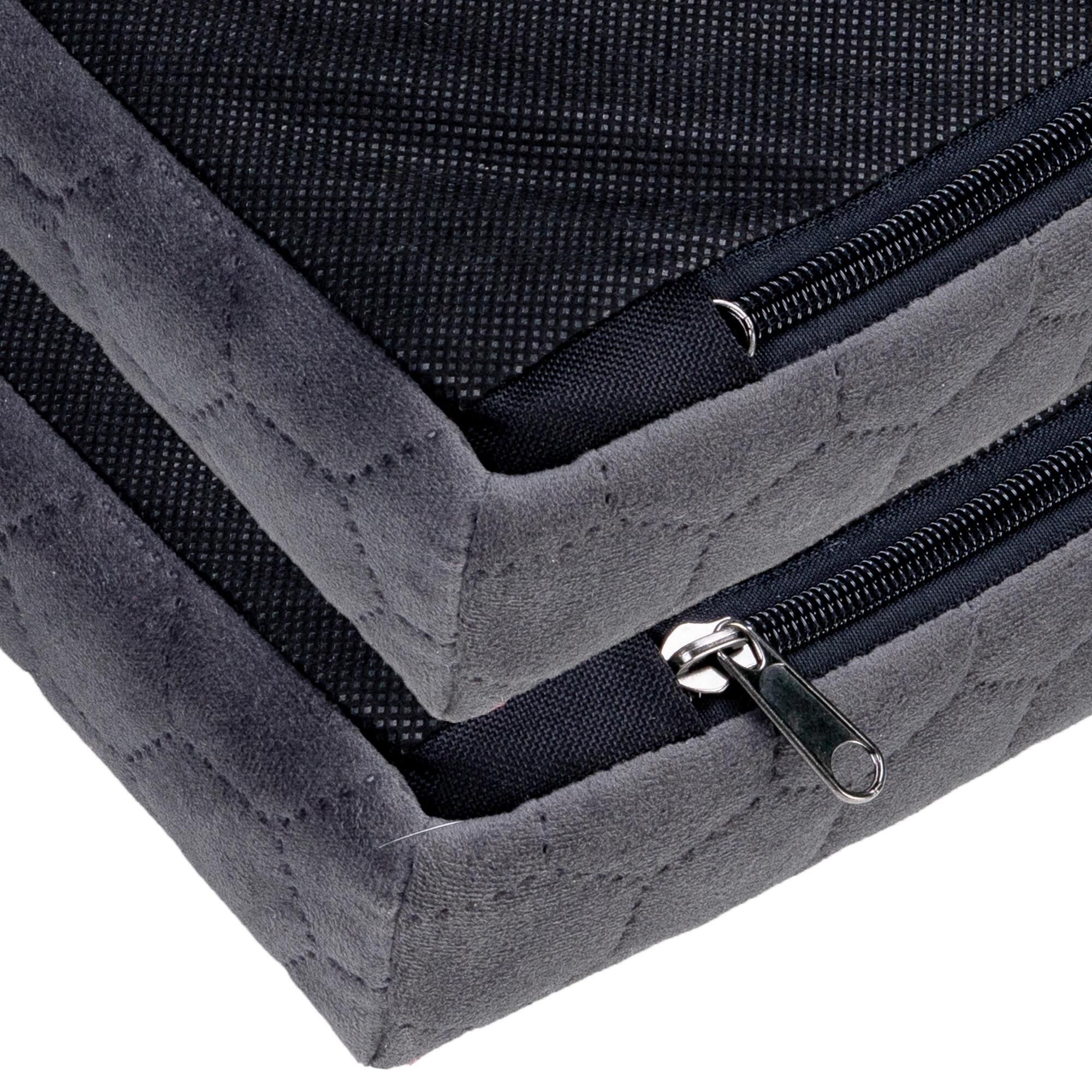 Nahaufnahme: Reißverschlüsse an dunkelgrauem Hundebett. Velours, geprägtes Muster. Metall-Zipper.