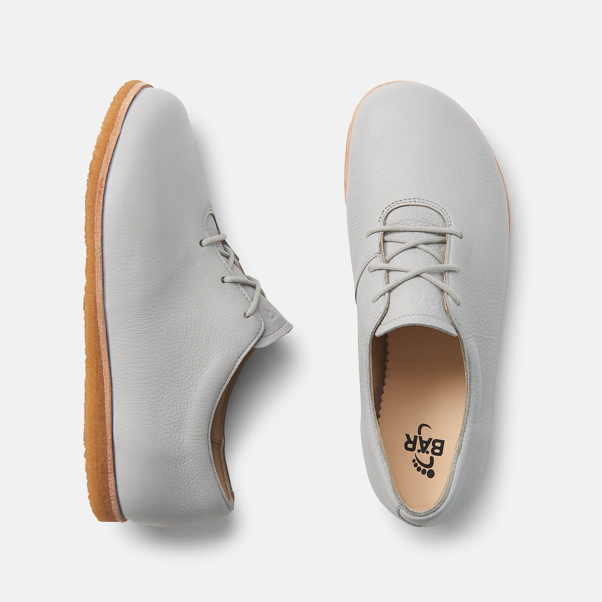 Hellgraue Schnürschuhe, Draufsicht. Ein Schuh von oben, der andere von der Seite.