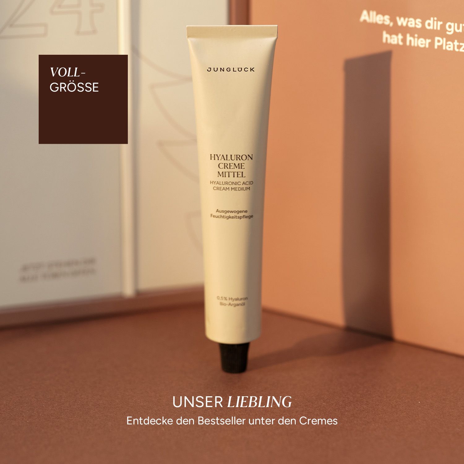 Beige Tube mit schwarzem Deckel. Text: JUNGLÜCK HYALURON CREME MITTEL. Text: Hyaluronic Acid Cream Medium.