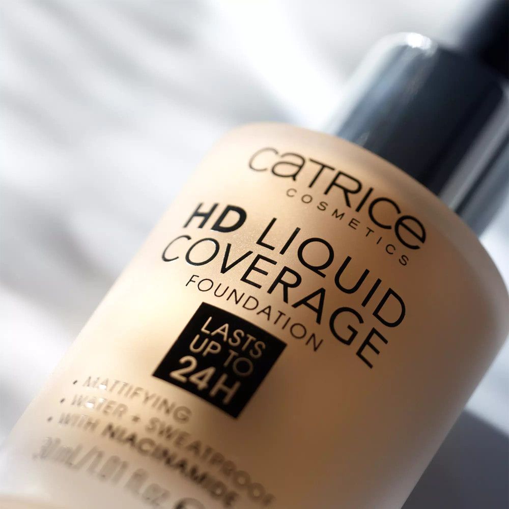 Nahaufnahme einer Foundation-Flasche. Aufschrift: Catrice, HD Liquid Coverage Foundation, hält bis zu 24 Stunden.