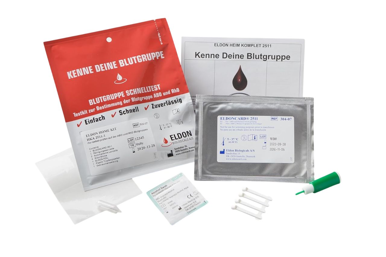 Blutgruppenschnelltest-Kit. Rote und silberne Verpackungen, grüne Lanzette, Teststreifen. Aufschrift: Eldon, Kenne Deine Blutgruppe.