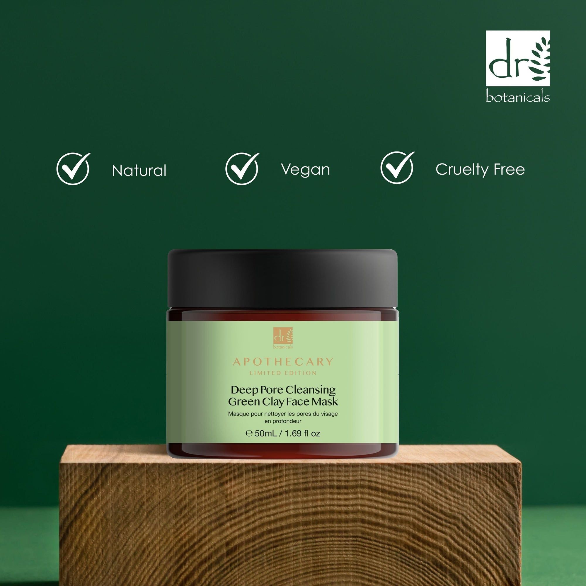 Gesichtsmaske auf Holzblock. Logos: Natural, Vegan, Cruelty Free. Produkt mit schwarzem Deckel und grüner Beschriftung.