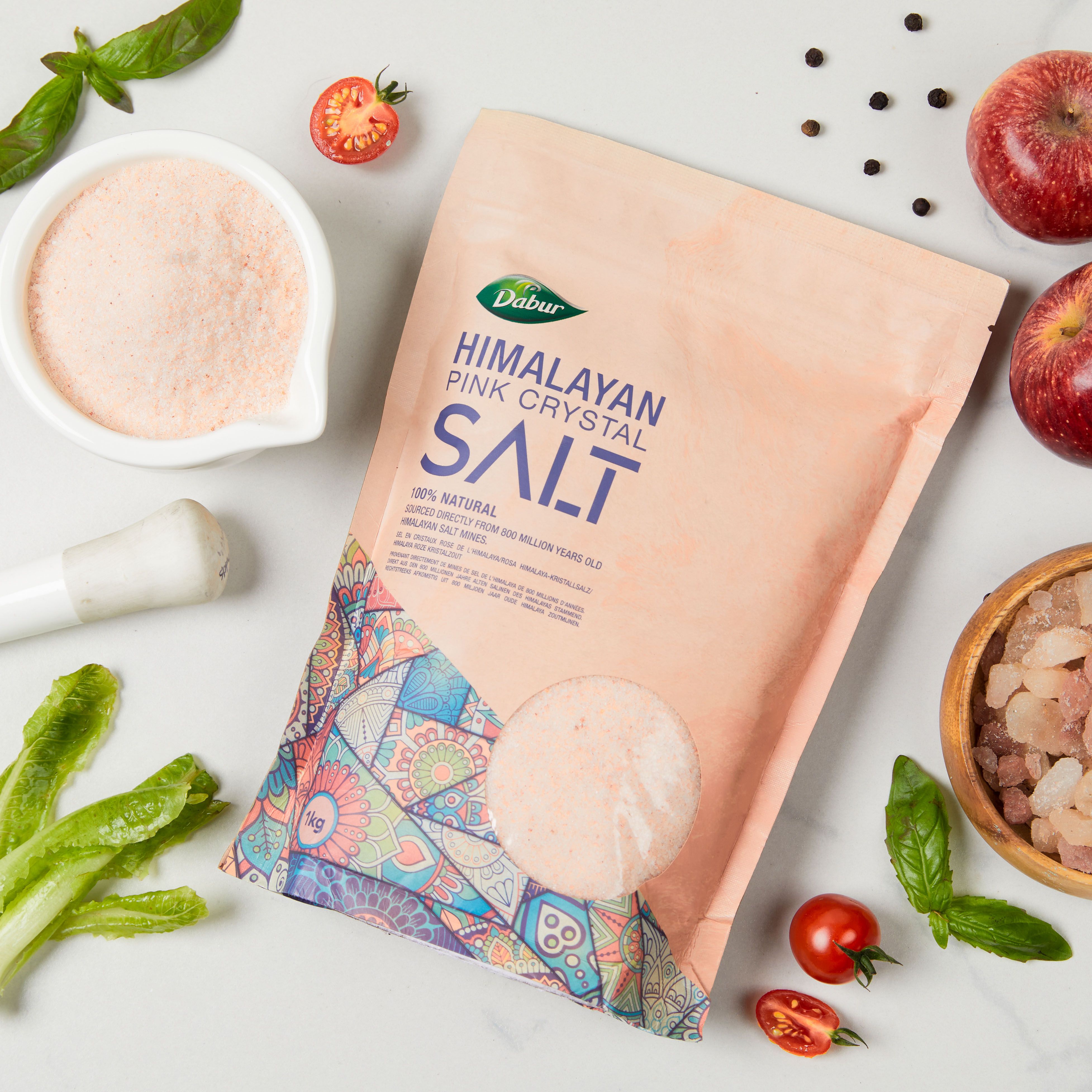 Dabur Himalayan Pink Crystal Salt Beutel. Rosa Salz, Tomaten, Äpfel, Basilikum. Aufschrift: 100% natürlich.