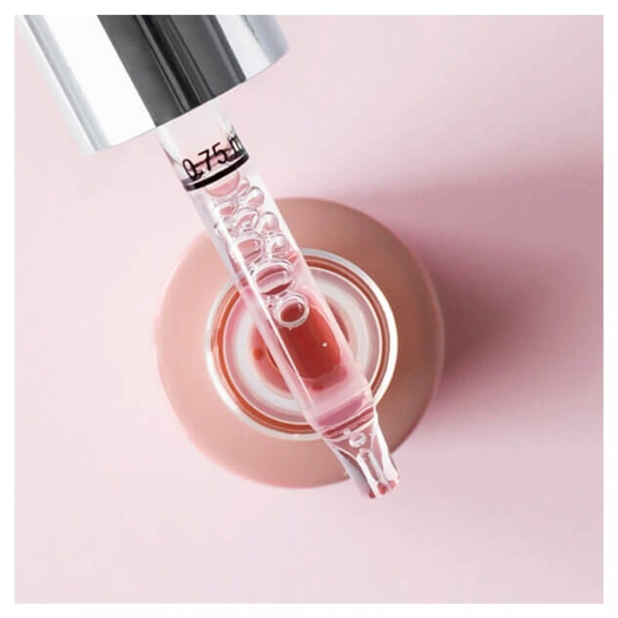 Nahaufnahme eines Pipettenkopfes mit rosa Serum und Blasen, der in eine offene Flasche mit der Markierung 0,75 ml abgesenkt ist.