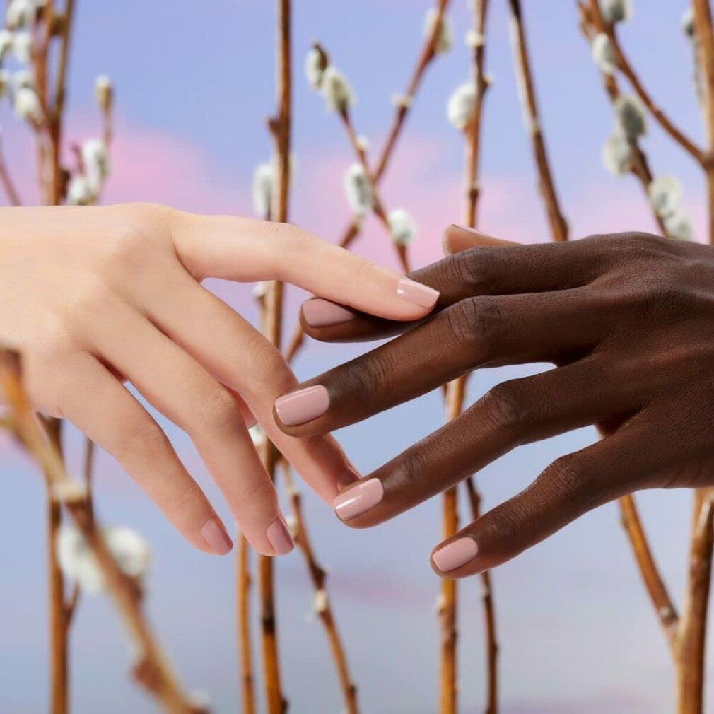 Zwei Hände mit lackierten Nägeln berühren sich. Der Nagellack ist rosa.