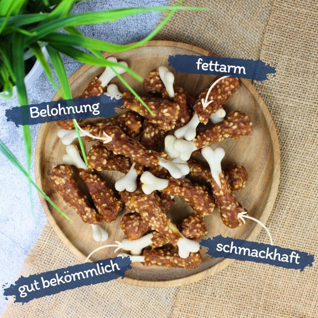 Hühnchenschenkel-Snacks auf Holztablett. Beschriftungen: Belohnung, fettarm, schmackhaft, gut bekömmlich.