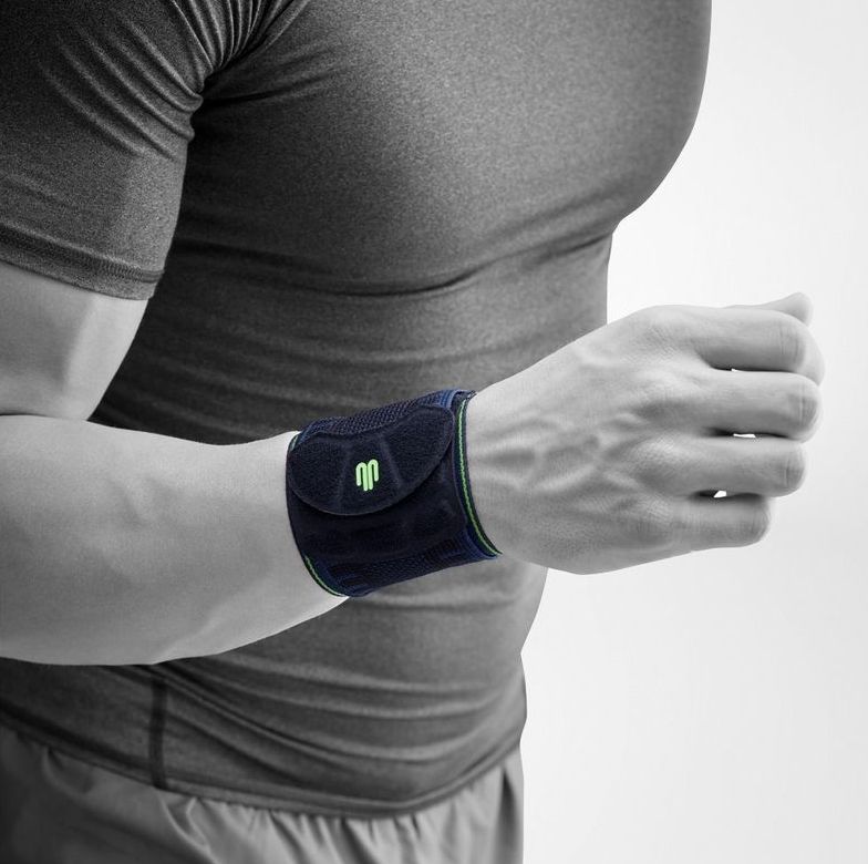Nahaufnahme eines Mannes mit einer Handgelenkbandage. Dunkelblaue Bandage mit grünen Akzenten.