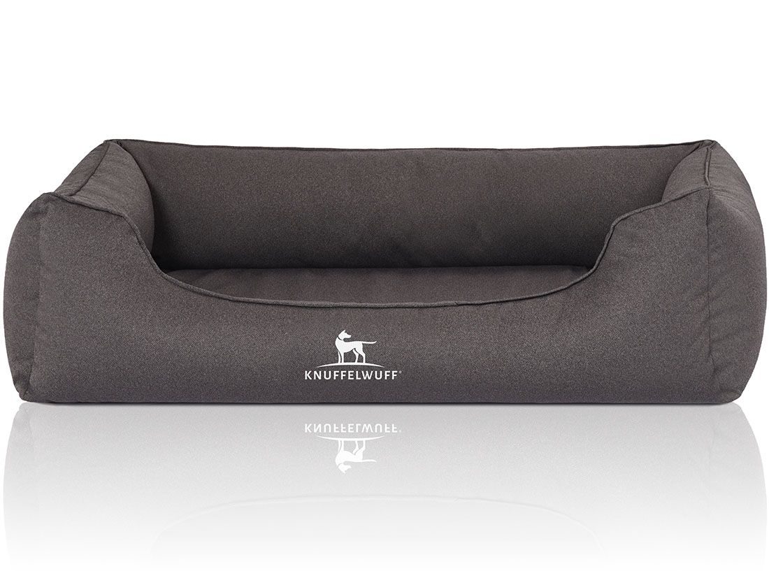 Graues orthopädisches Hundebett Leon. Rechteckige Form mit erhöhtem Rand. Knuffelwuff Logo. Reflektierende Oberfläche.