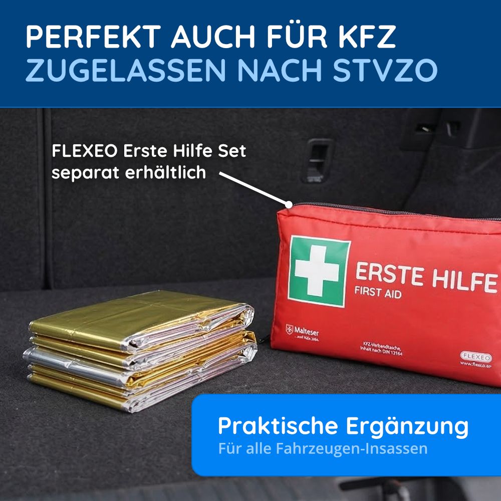 Gestapelte goldene Rettungsdecken neben rotem Erste-Hilfe-Kasten im Kofferraum.