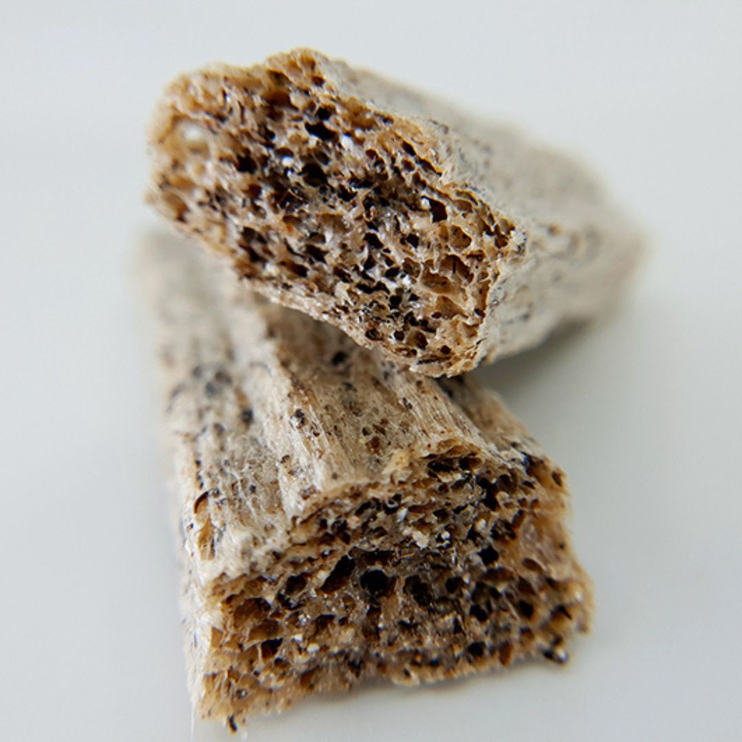 Nahaufnahme von zwei Puffed Cheese. Die Oberfläche ist uneben und weist eine helle, beige Farbe auf.