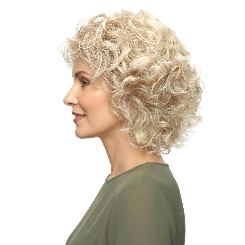 Perücke mit lockigem, blondem Haar. Die Frau trägt ein grünes Oberteil. Seitenansicht.