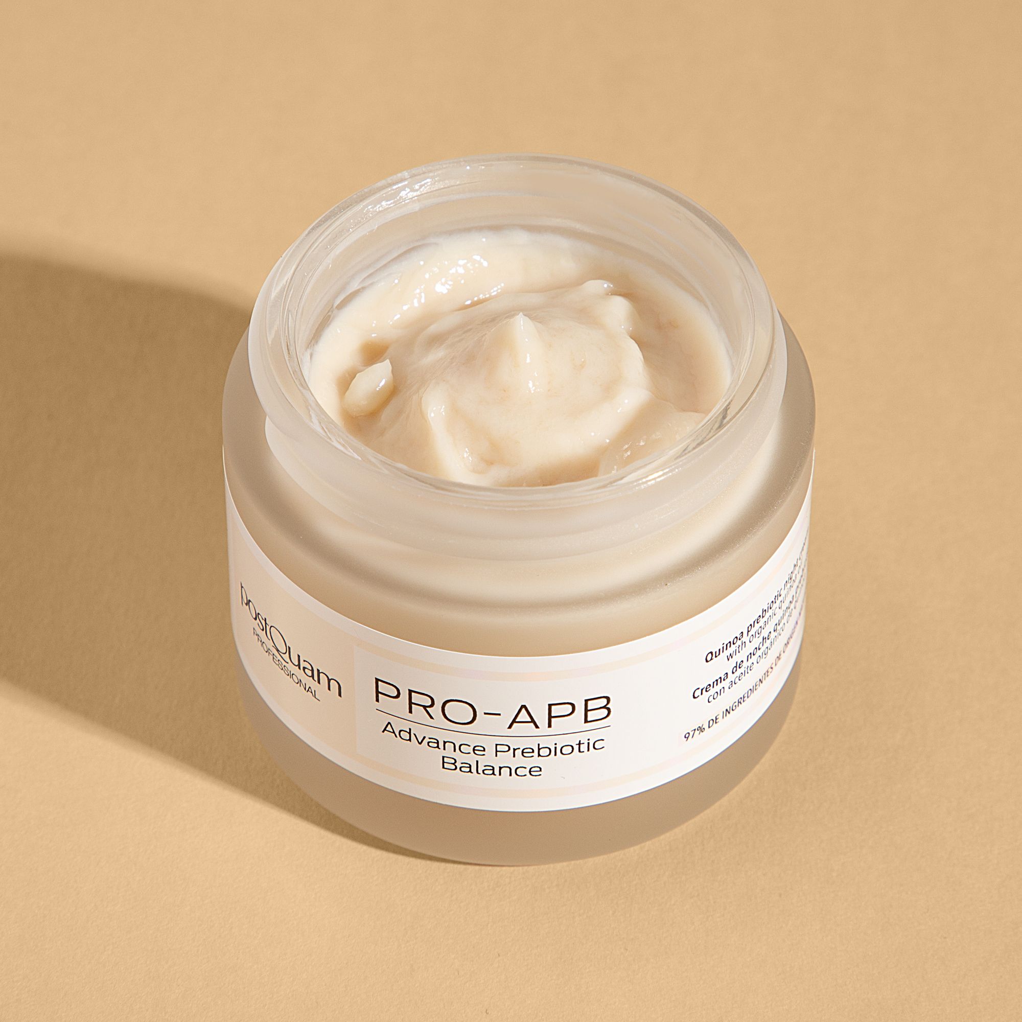Geöffneter Creme-Tiegel. Creme sichtbar. Aufschrift: Postquam, PRO-APB, Advance Prebiotic Balance. Text: Quinoa Prebiotic Nachtcreme. 97% Inhaltsstoffe.