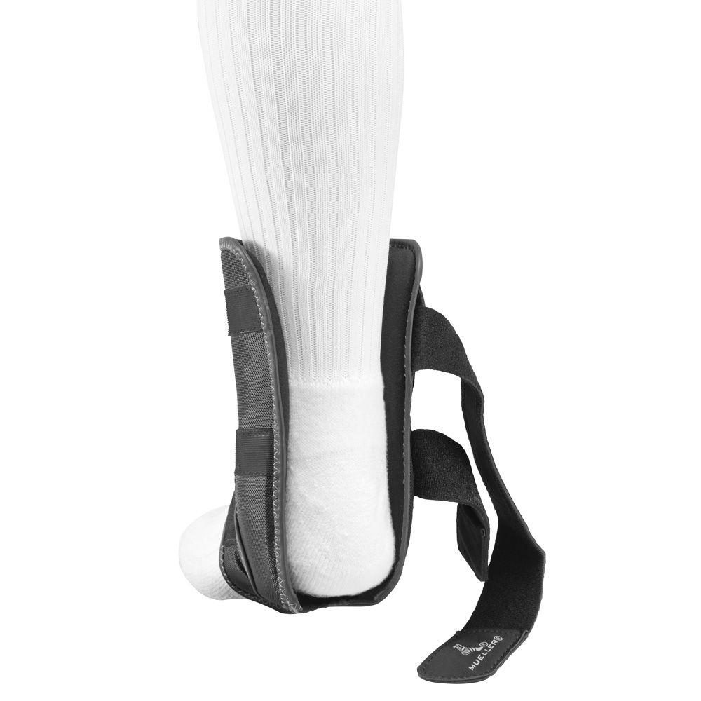 Schwarze Knöchelbandage mit Klettverschluss. Am Bein getragen, mit weißem Socken.