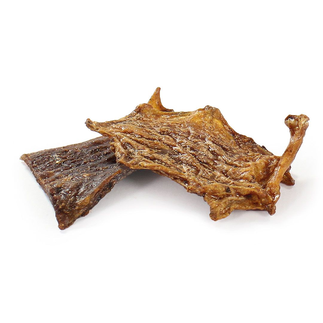 Zwei getrocknete, fleischige Snacks. Einer rechteckig, der andere unregelmäßig geformt mit Knochenansatz. Hellbraune Farbe.