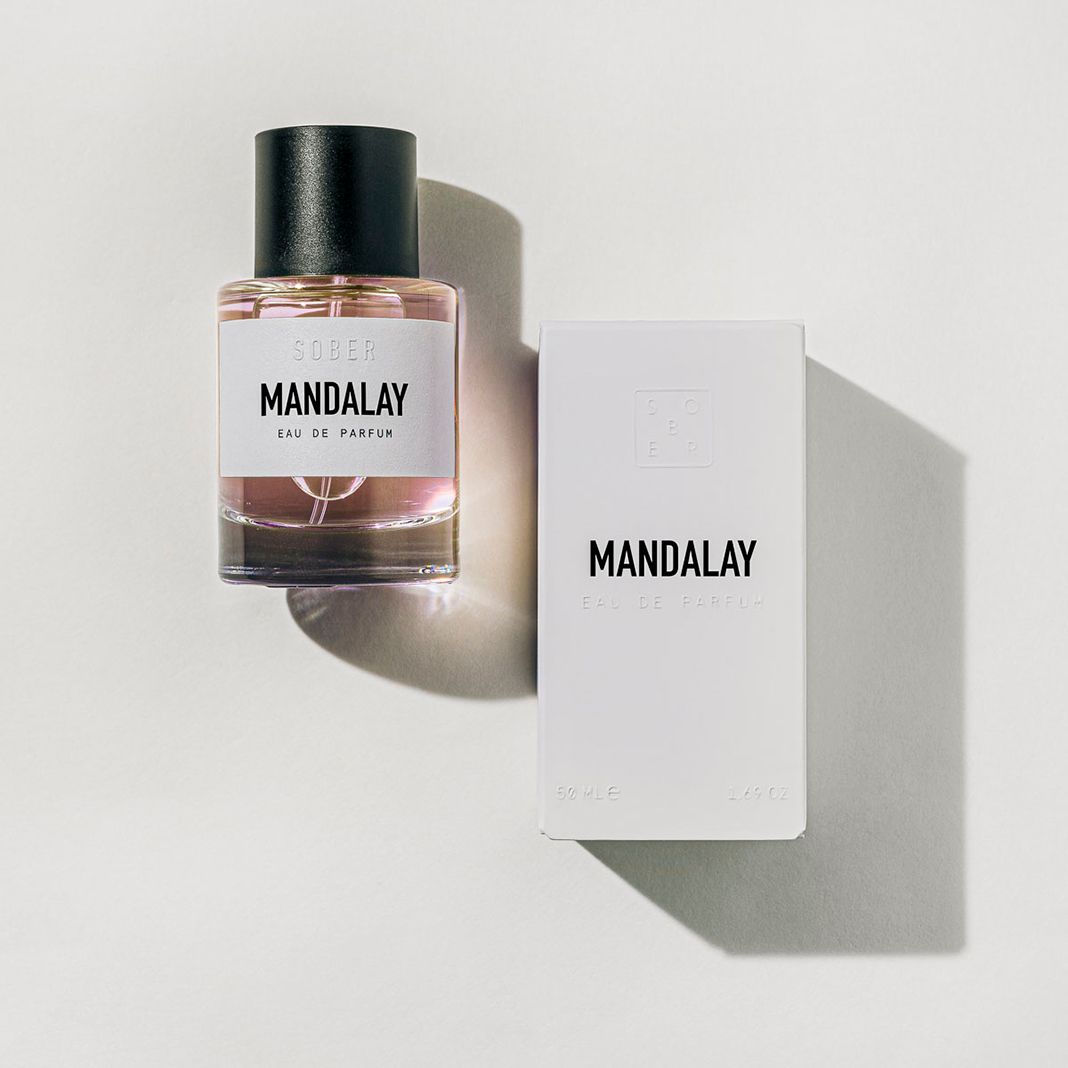 SOBER BERLIN MANDALAY Eau de Parfum Flakon und Verpackung. Flakon mit schwarzem Deckel und weißem Etikett. Verpackung weiß mit schwarzem Schriftzug.