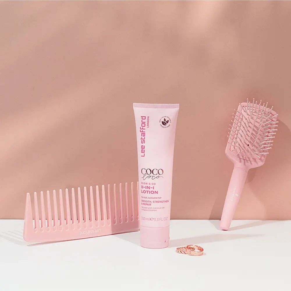 Ein rosa Kamm, eine rosa Haarbürste und eine rosa Tube Lee Stafford Coco Loco 8-in-1 Lotion.