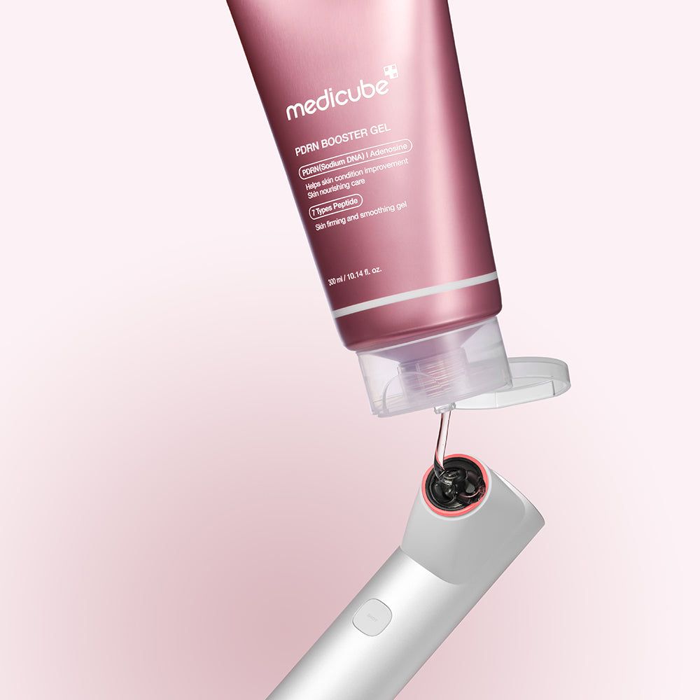 Rosa Tube MEDICUBE PDRN Booster Gel, Gel wird auf ein Gerät aufgetragen. Rosa Hintergrund.