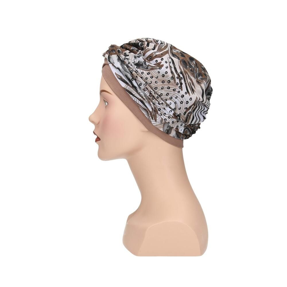 Turban Livia von Turbane, beige und gemustert. Auf einer Büste präsentiert. Seitenansicht.